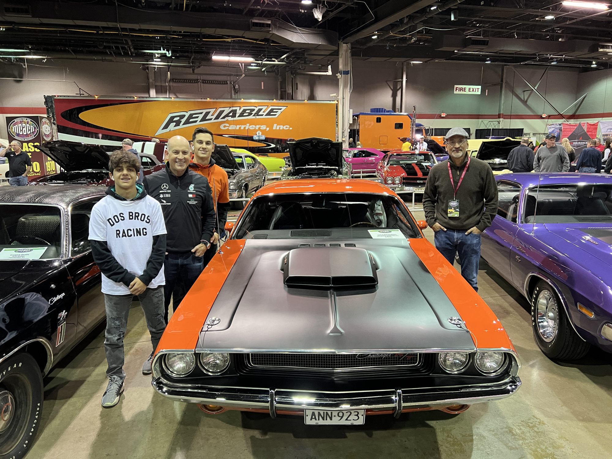 Group of men standing next to their vintage Dodge vehicle