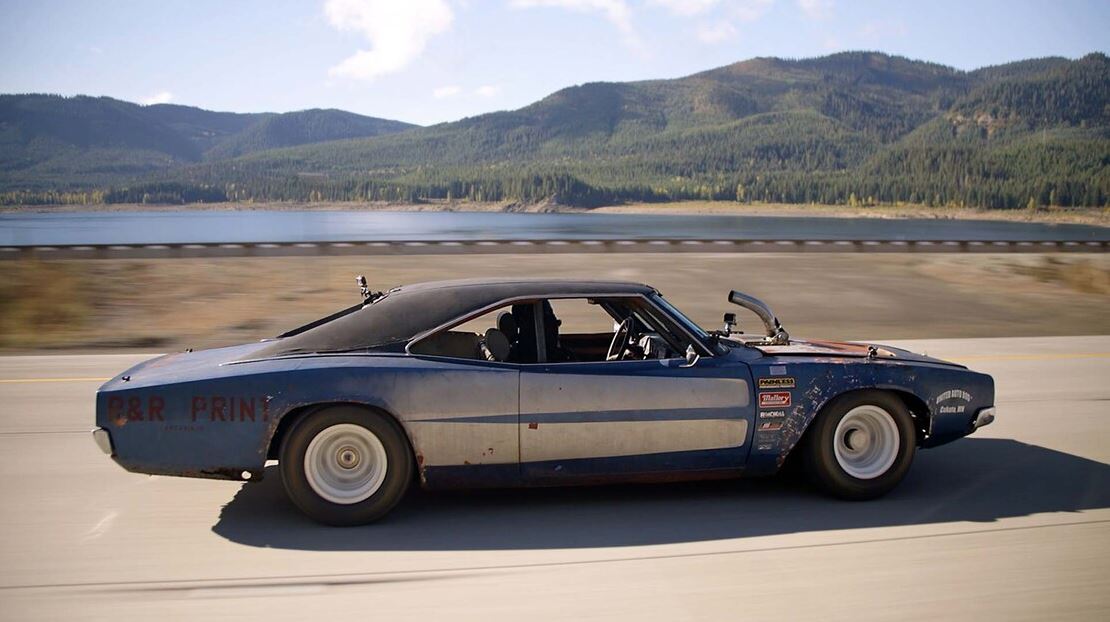 A vintage Dodge Charger driving down the road