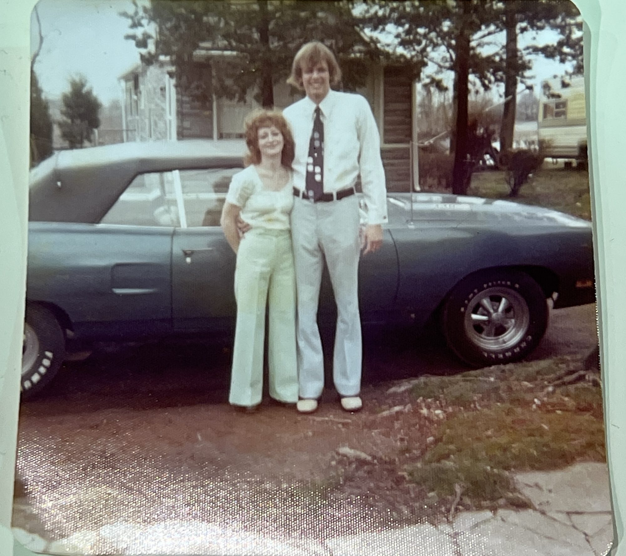 man and woman standing in front of a vehicle