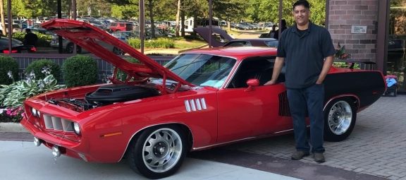 Man standing next to vintage Dodge vehicle