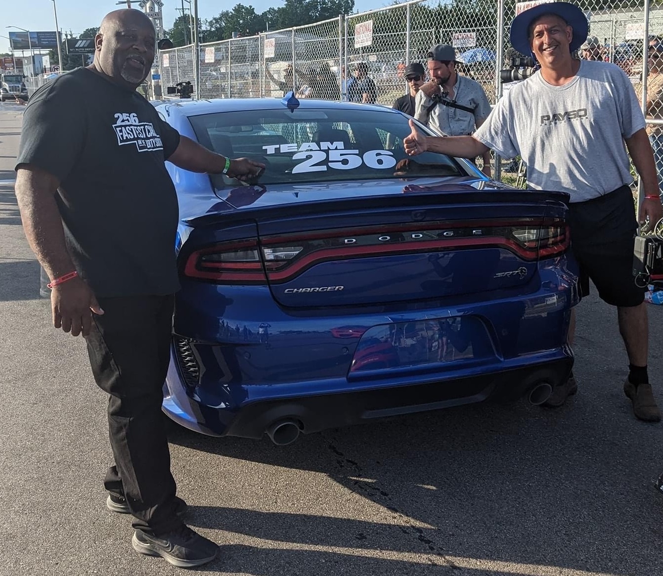 Two men standing next to a Dodge vehicle