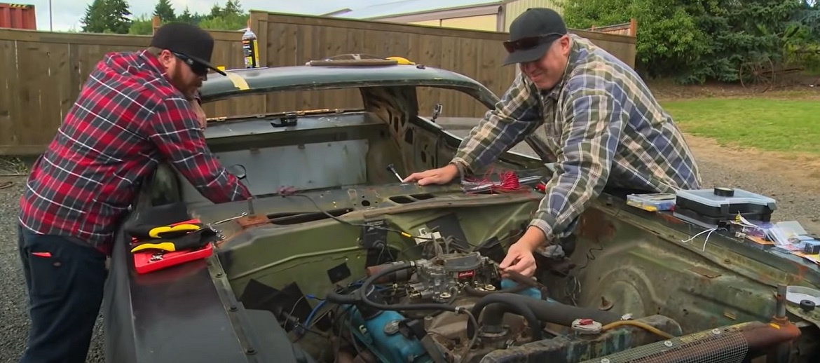 Two men working on a vehicle