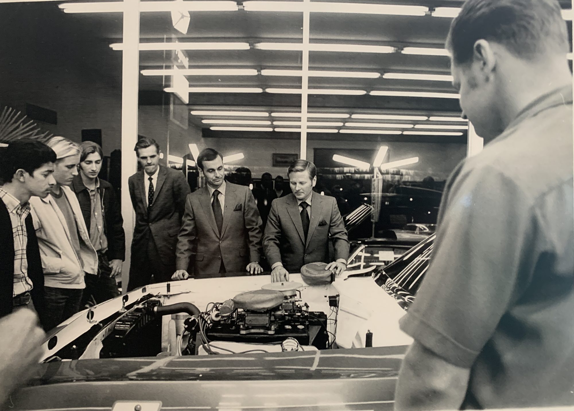 Men standing around a car in a studio