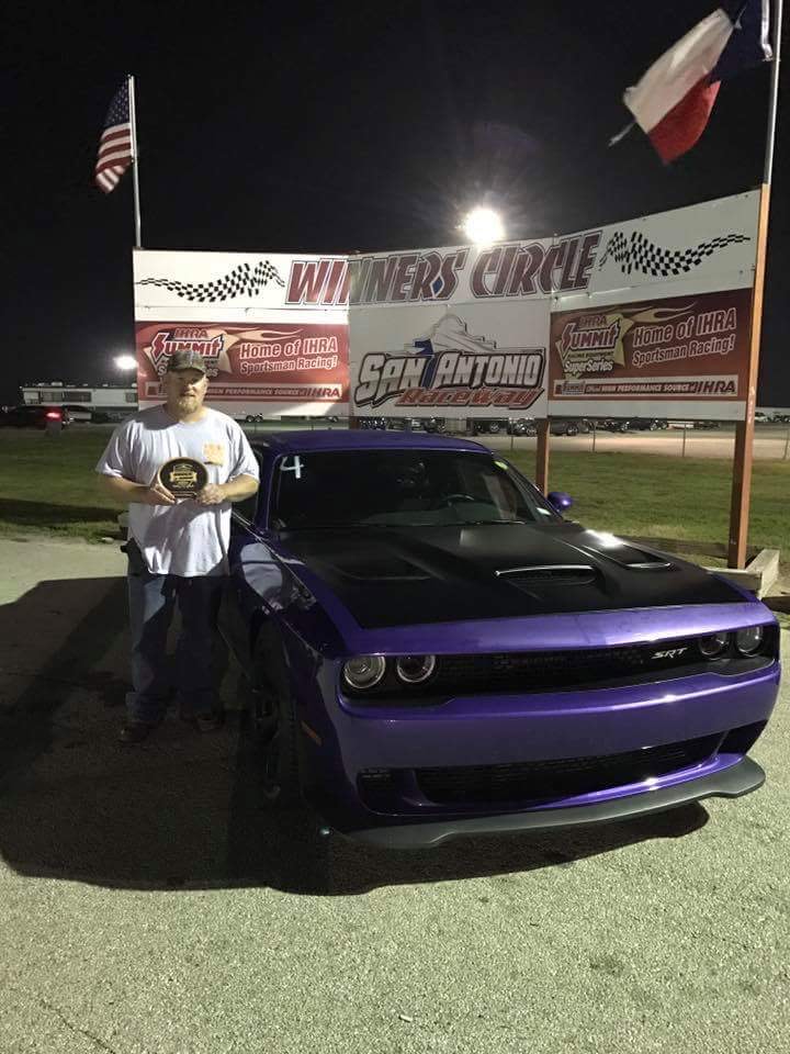 Man standing next to his car with a trophy