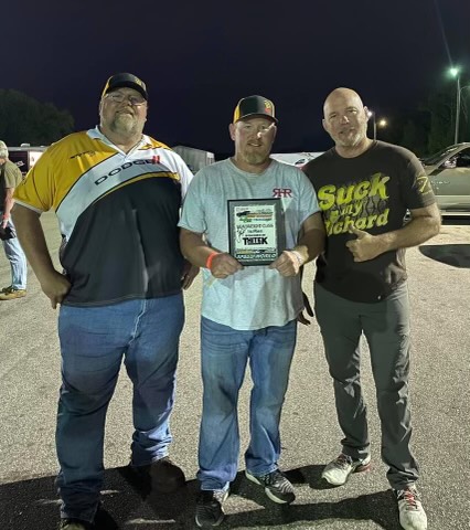 Three men posing with a trophy