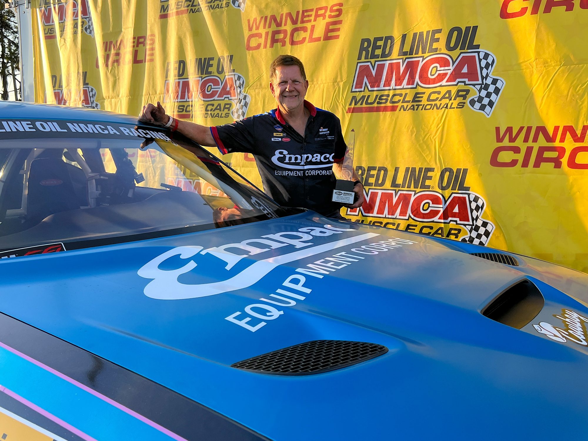 Man standing next to his race car