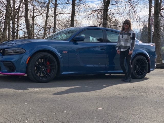 Woman standing next to a Charger Scat Pack