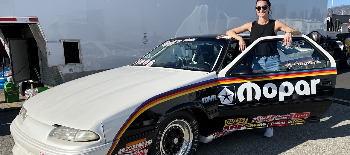 Woman standing with her race car