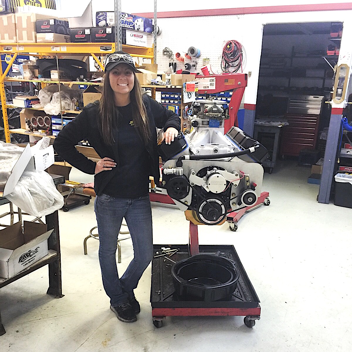 woman standing next to a HEMI engine