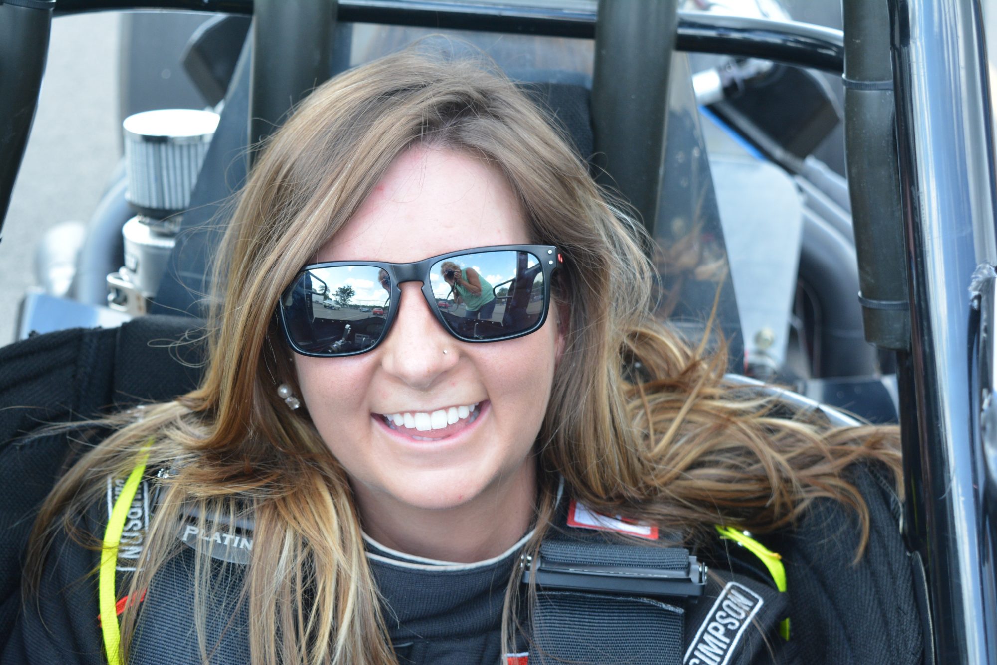 woman sitting inside of her race car