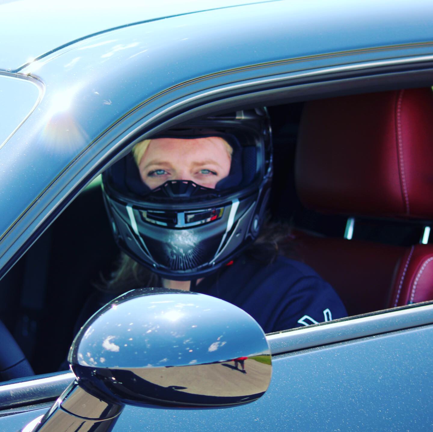 woman sitting inside a car getting ready to race