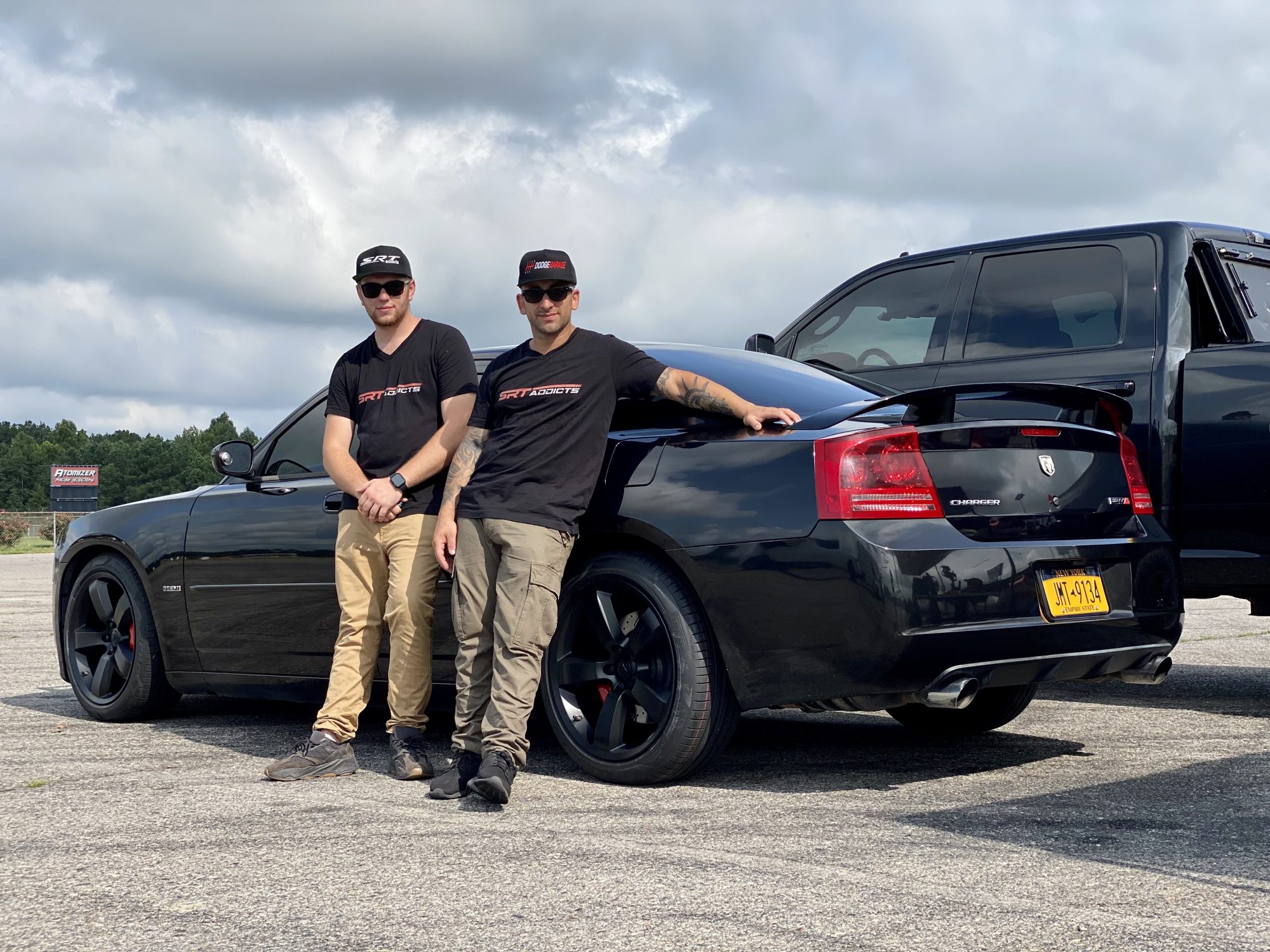 men posing with their car