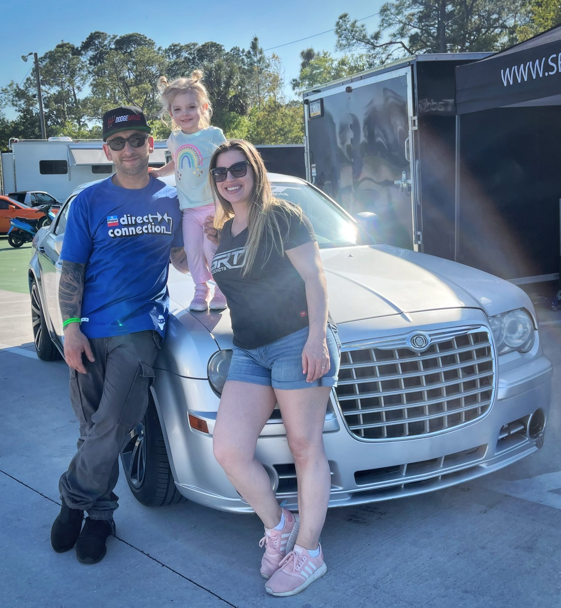 family posing with their car