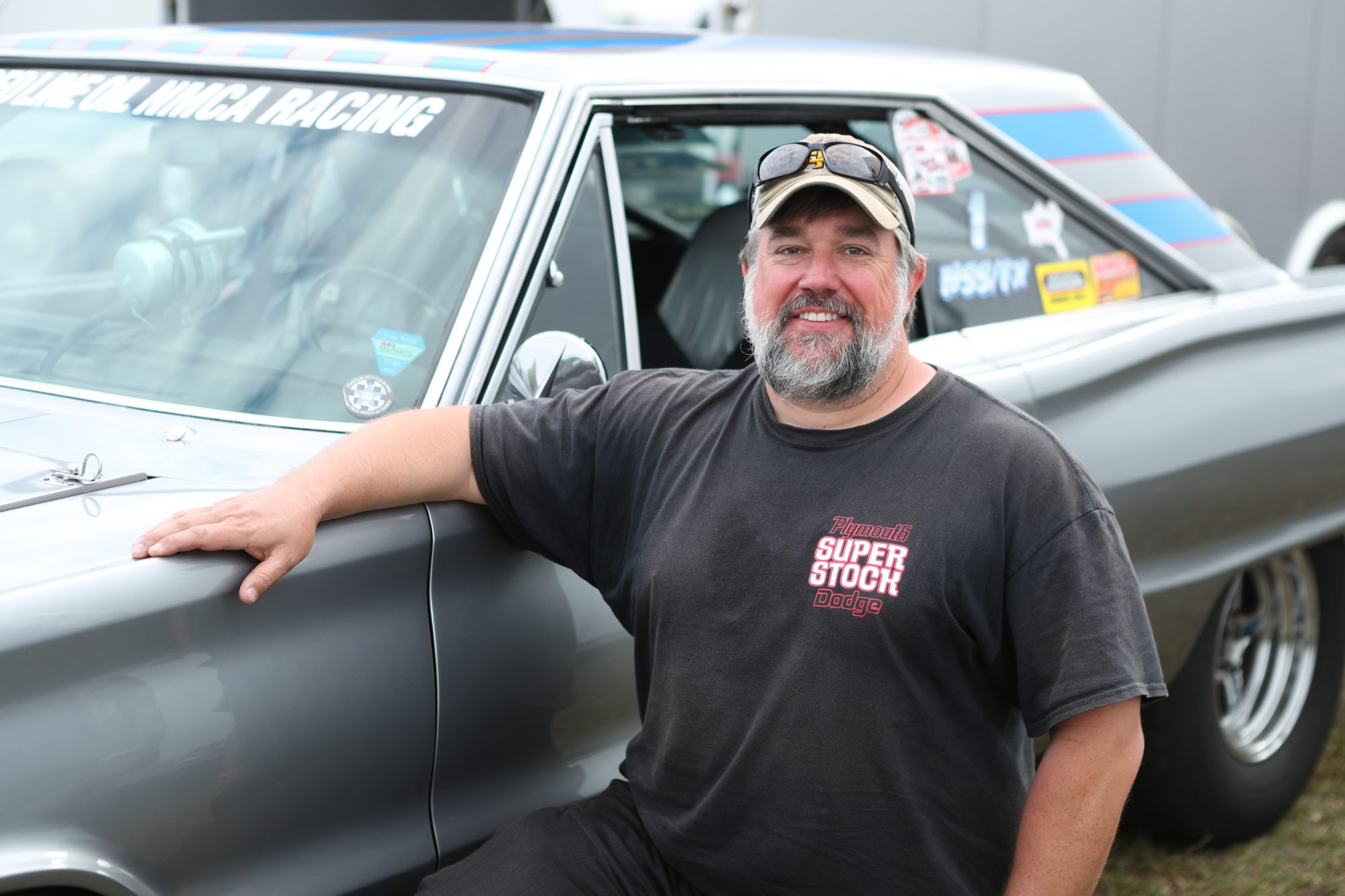 man standing next to his race car