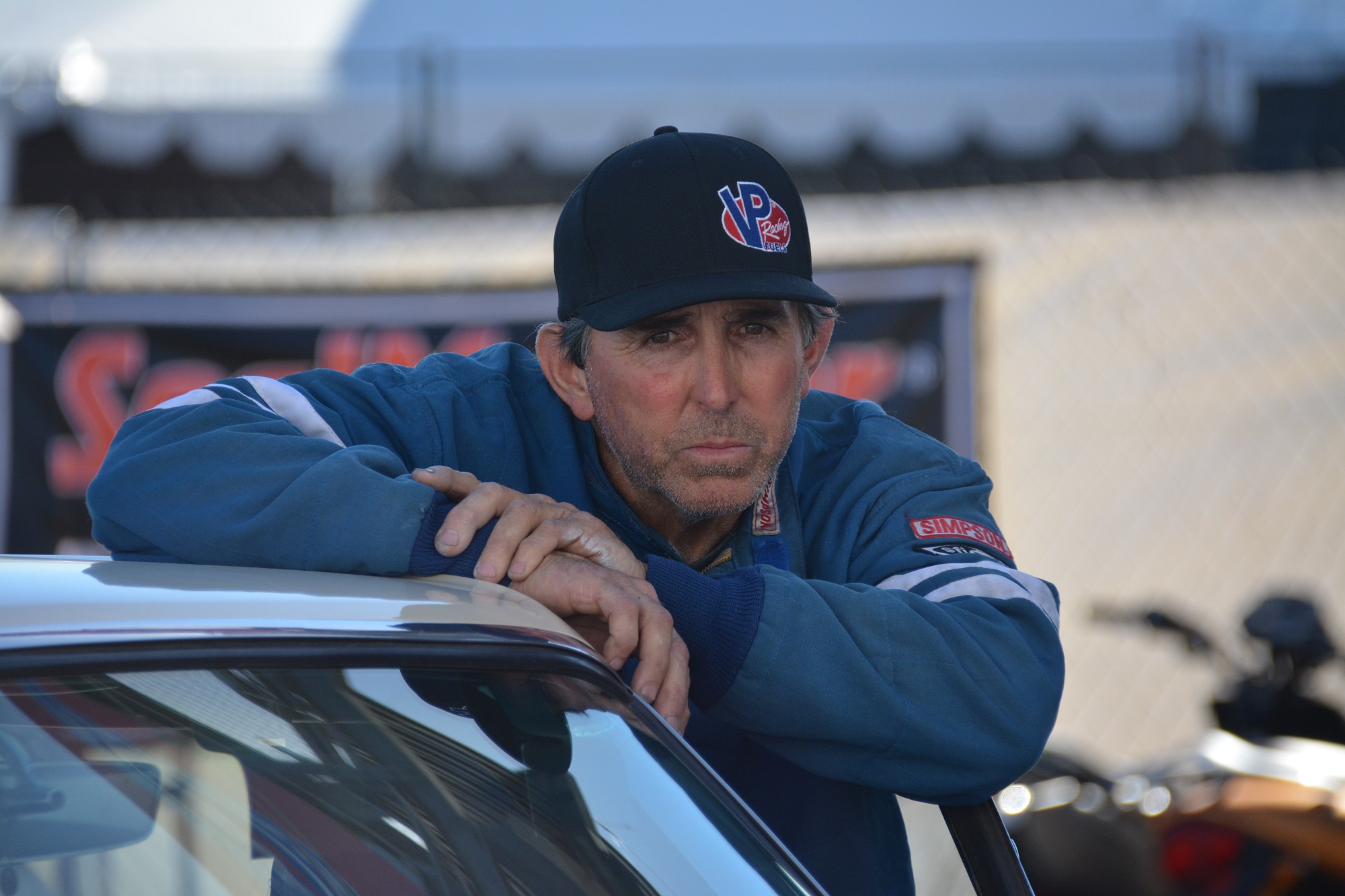 man standing with his race car