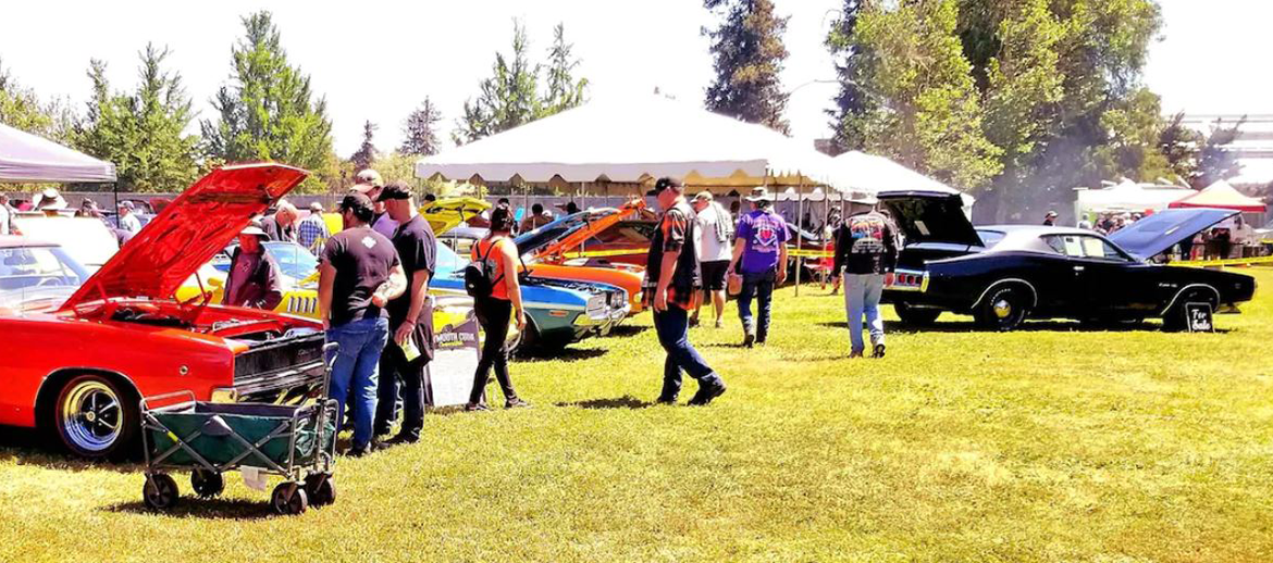 Event spectators browsing classic Mopar vehicles on display