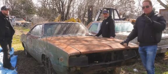 Dennis Collins with a rusted classic muscle car
